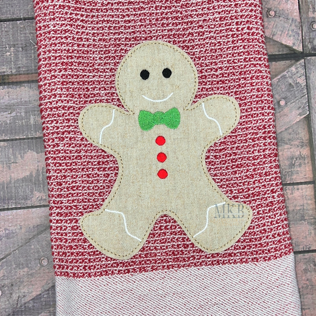 gingerbread boy bean stitch applique. gingerbread has a bow tie and buttons.