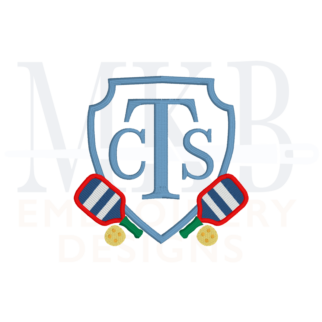 Monogram crest Frame with pickleball rackets and balls on the left and right side of the frame.
